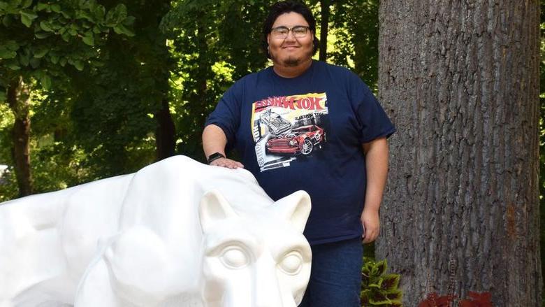 Man standing behind lion statue